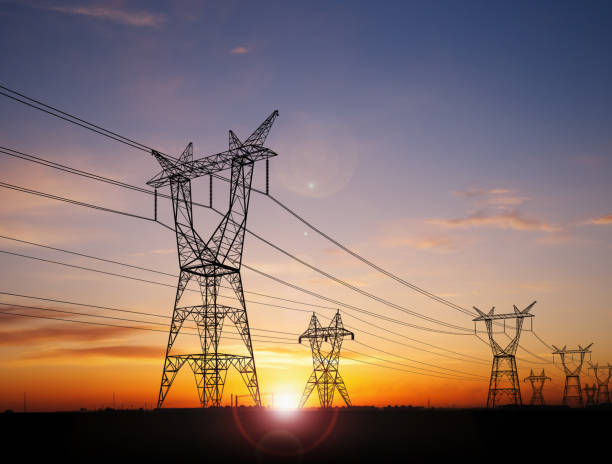 Dubai's energy supply: High-voltage electrical transmission lines against a sunset sky